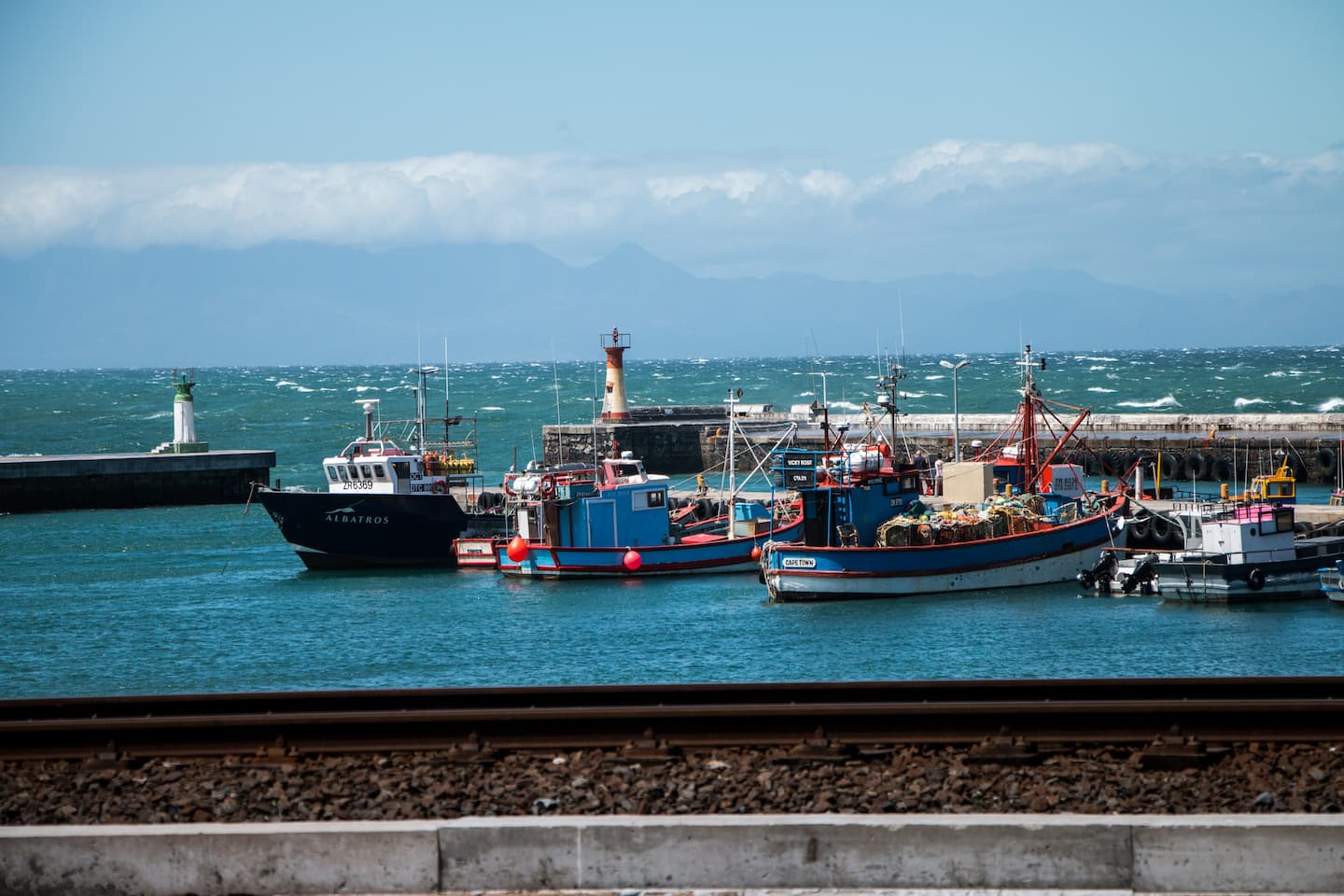 Kalk Bay harbour with colourful fishing boats, lighthouse and False Bay